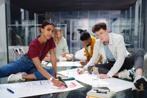 Universitaire studenten activisten maken spandoeken voor protest binnen, vechten voor gratis onderwijs concept. — Stockfoto