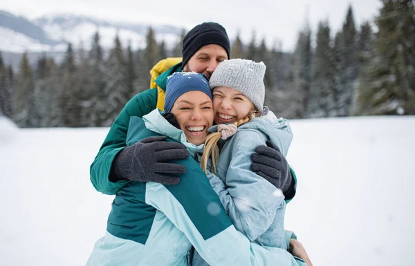 Familj med liten dotter kramas utomhus i vinter natur, Tatrabergen Slovakien. — Stockfoto