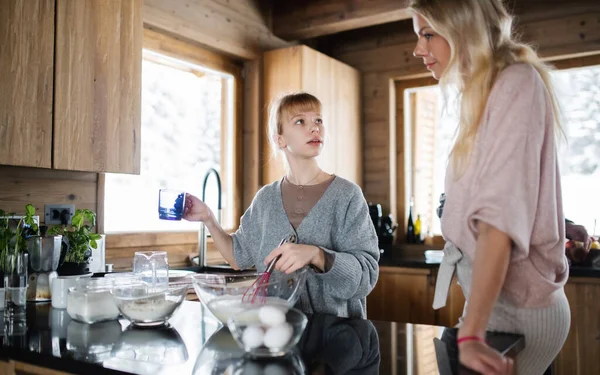 Äiti pieni tytär ruoanlaitto sisätiloissa, talviloma yksityisessä asunnossa. — kuvapankkivalokuva