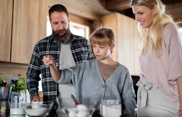 Familj med liten dotter matlagning inomhus, vinter semester i privat lägenhet. — Stockfoto