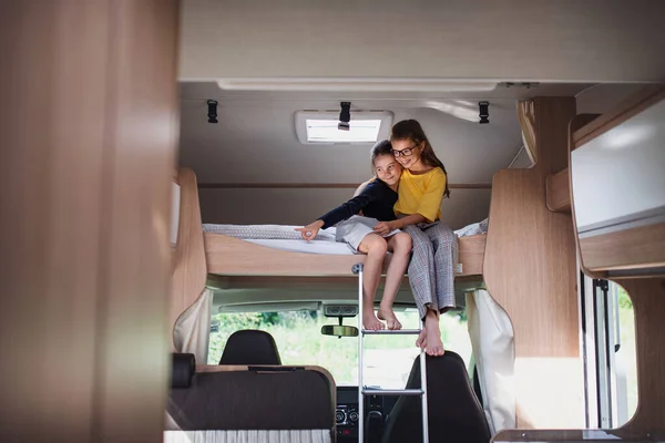 Dívky sestry sedí na lůžku v karavanu, rodinný výlet. — Stock fotografie