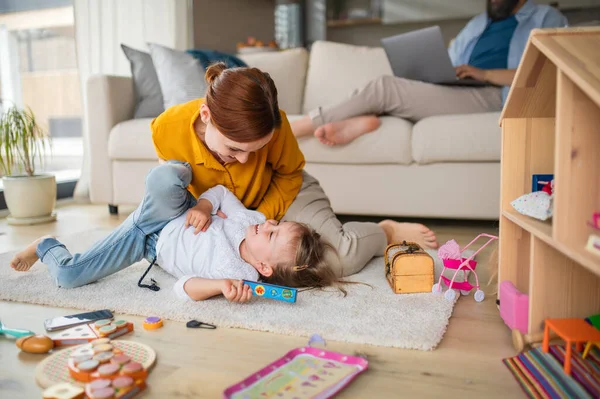 Moeder met kleine dochter spelen binnen thuis, dagelijks leven en thuis kantoor met kind concept. — Stockfoto