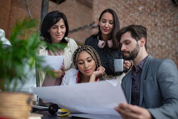 Jovens e velhos empresários sentados e a trabalhar à secretária no escritório, conceito de cooperação. — Fotografia de Stock