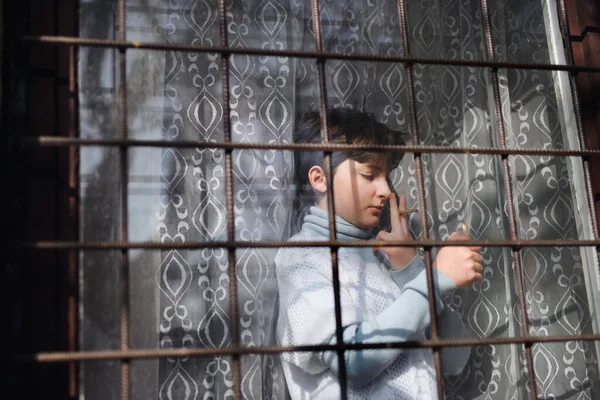 Zavallı üzgün küçük kız evde durmuş sigara içiyor, fakirlik ve koronavirüs konsepti.