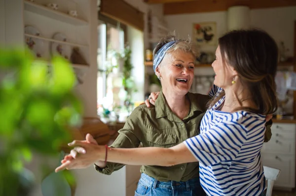 Feliz madre mayor divirtiéndose con la hija adulta en casa, bailando. — Foto de Stock