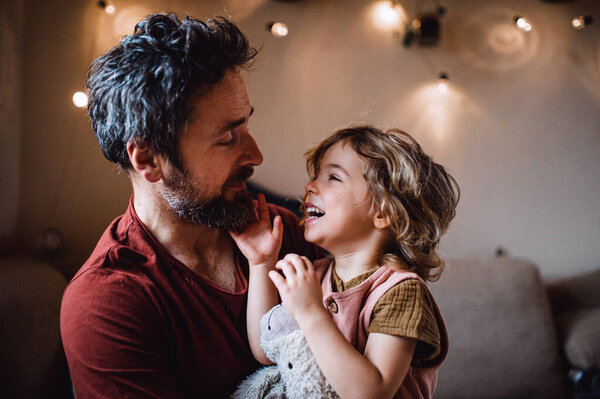 Mature father with small daughter standing indoors at home, holding and hugging. — Stock Photo, Image