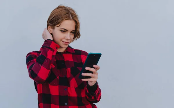 Νεαρή γυναίκα βγάζει selfie σε εξωτερικούς χώρους με λευκό φόντο, έννοια των κοινωνικών δικτύων. Αντιγραφή χώρου. — Φωτογραφία Αρχείου