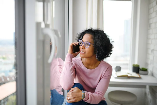 Retrato de mujer madura feliz haciendo una llamada telefónica en el interior, mirando por la ventana. — Foto de Stock