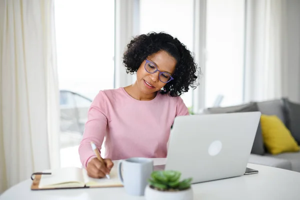 Retrato de mujer madura feliz trabajando en el ordenador portátil en el interior, concepto de oficina en casa. — Foto de Stock