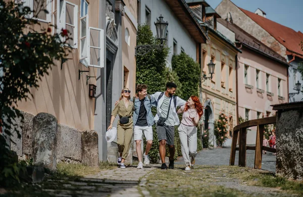 Přední pohled na skupinu šťastných mladých lidí venku na výletě ve městě, procházky a mluvení. — Stock fotografie