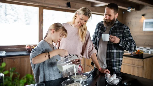 Семья с маленькой дочерью готовит дома, зимний отдых в частной квартире. — стоковое фото