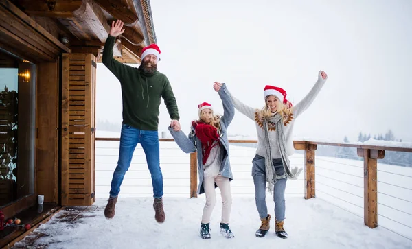 Familia con hija pequeña divirtiéndose en la terraza al aire libre, vacaciones en Navidad. —  Fotos de Stock