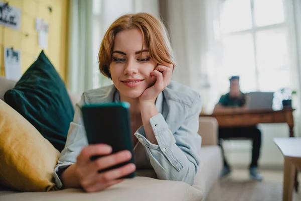 Pareja joven en casa usando divice digitales, smartphone y laptop, concepto de redes sociales. — Foto de Stock