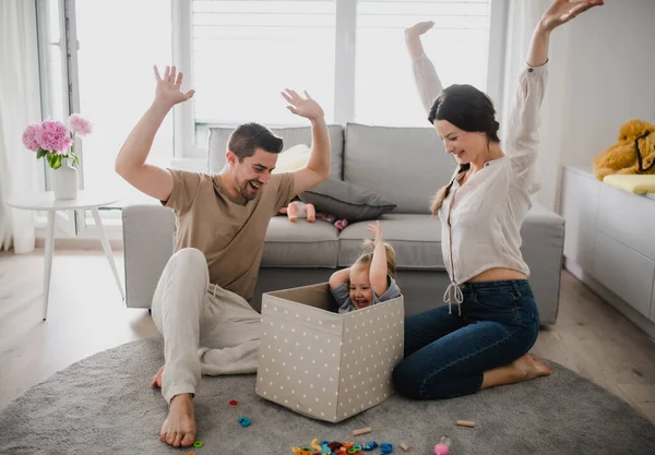 Mutlu genç bir aile ve küçük bir kız evde oyun oynuyor ve birlikte eğleniyorlar.. — Stok fotoğraf