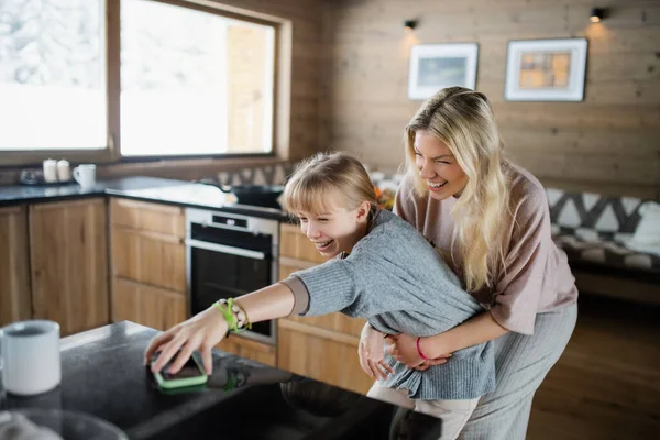 Moeder met kleine dochter hebben plezier binnen in de winter vakantie prive-appartement. — Stockfoto