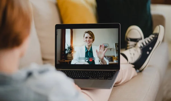 Vista trasera de la mujer joven en casa haciendo videollamada usando tableta, concepto de redes sociales. — Foto de Stock