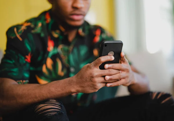 Retrato de jovem irreconhecível usando smartphone, sentado no sofá em casa, conceito de redes sociais. — Fotografia de Stock