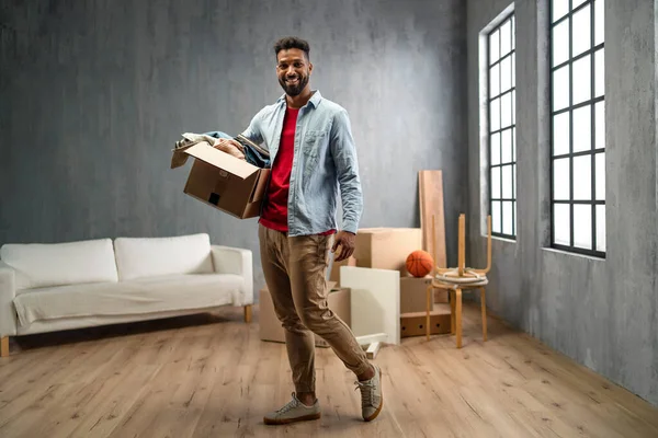 Happy young man holding packing boxes moving home, looking at camera, new living concept. — Stock Photo, Image