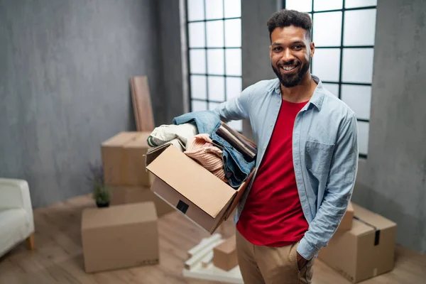 Happy young man holding packing boxes moving home, looking at camera, new living concept. — Stock Photo, Image