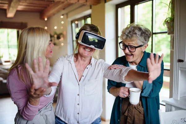 Щасливі старші жінки друзі розважаються з окулярами віртуальної реальності вдома . — стокове фото