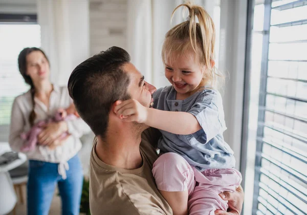 Щаслива молода сім'я з новонародженою дитиною і маленькою дівчинкою насолоджується разом вдома . — стокове фото