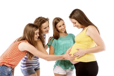 Girls touching pregnant woman's belly clipart