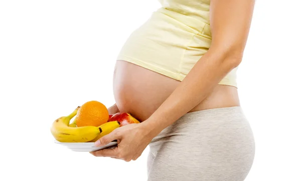 Беременная женщина со свежими фруктами — стоковое фото