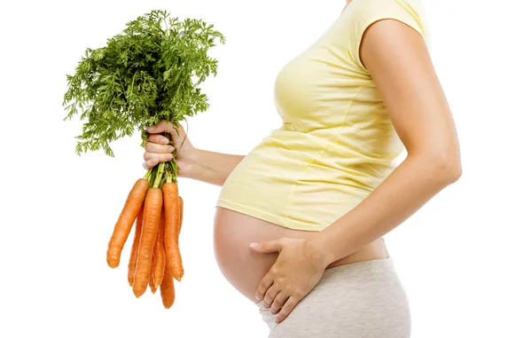 Donna incinta con carote in mano — Foto Stock