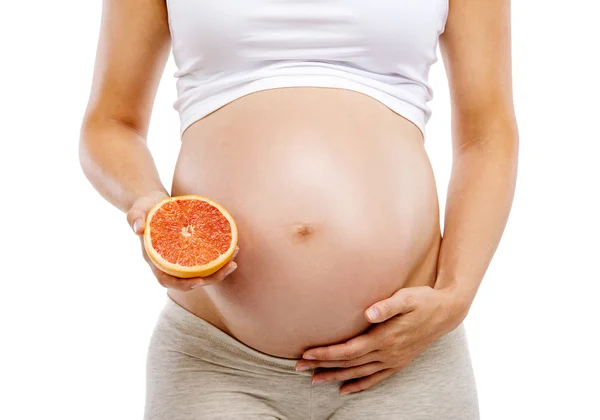 Zwangere vrouw met de helft van grapefruit — Stockfoto