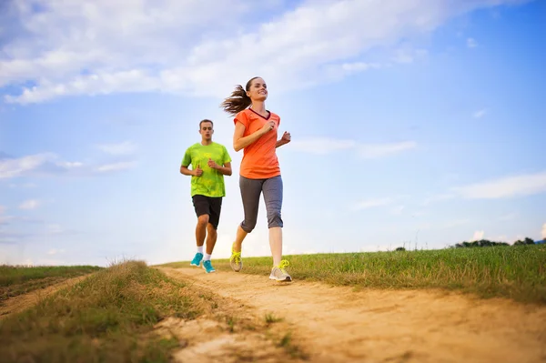 Pareja corredora haciendo ejercicio al atardecer . — Foto de Stock