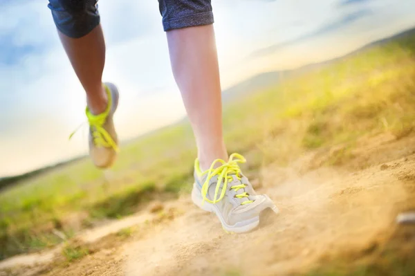 Female feet running on countryside road — Stock Photo, Image