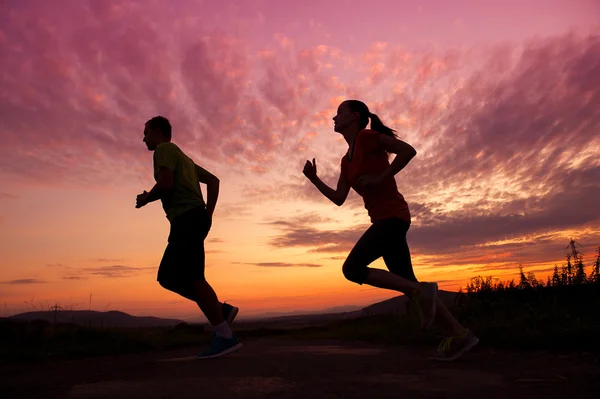 Couple running in sunset — Stock Photo, Image