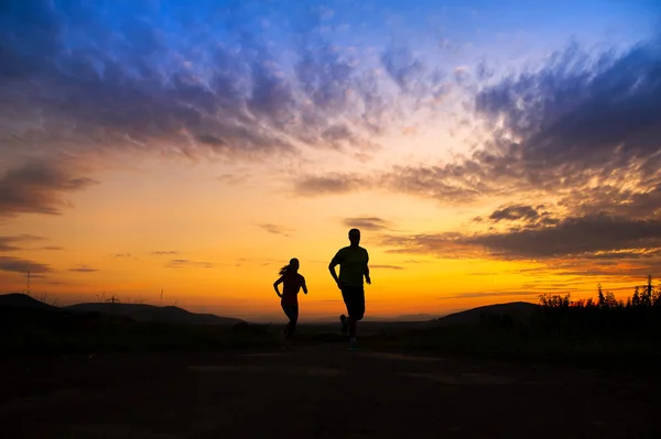 Couple running in sunset — Stock Photo, Image