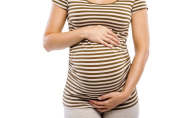 Hamile kadın karnına dokunuyor.