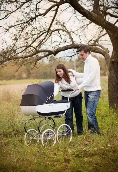 Foreldre med baby i veteranvogn – stockfoto