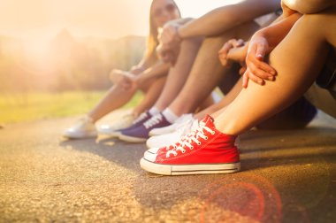 Boys and girls sitting on the sidewalk clipart