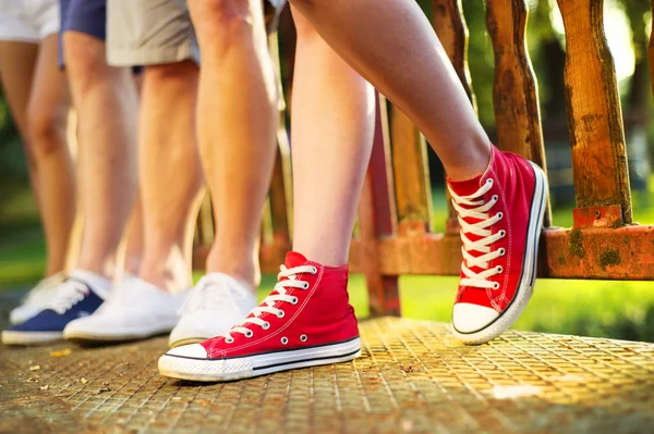 Legs of boys and girls standing on the sidewalk — Stock Photo, Image