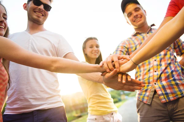 Grupp människor med händerna i stacken — Stockfoto