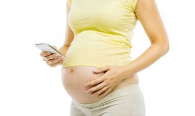 Cep telefonu kullanan hamile bir kadın.