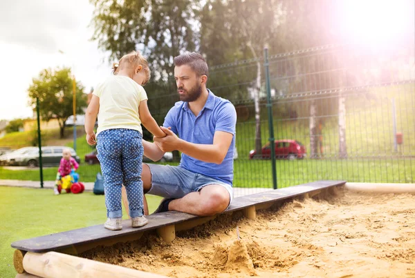 Ojciec i córka grając na plac zabaw dla dzieci. — Zdjęcie stockowe