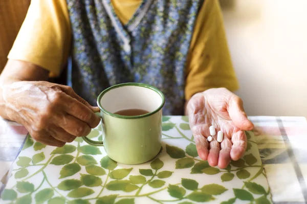 Alte Frau hält Tabletten in der Hand — Stockfoto