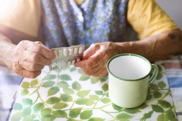 Old woman's hands holding pills — Stock Photo, Image