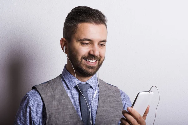 Бизнесмен слушает музыку с мобильного телефона — стоковое фото