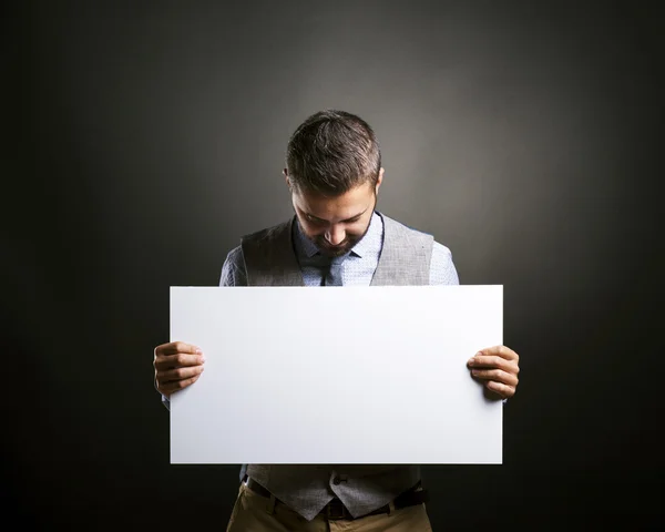 Empresário segurando cartaz em branco — Fotografia de Stock