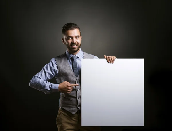 Empresario sosteniendo cartel en blanco — Foto de Stock