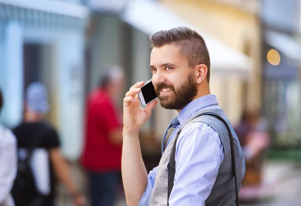 Businessman talking on mobile phone in town — Stock Photo, Image