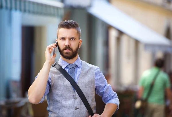 Businessman talking on mobile phone in town — Stock Photo, Image