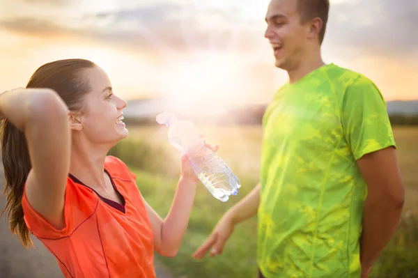 Correndo casal tendo quebra de água — Fotografia de Stock