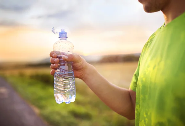 Uomo che ha una pausa acqua al tramonto — Foto Stock