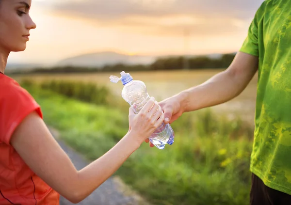 Coppia che corre avendo pausa acqua — Foto Stock